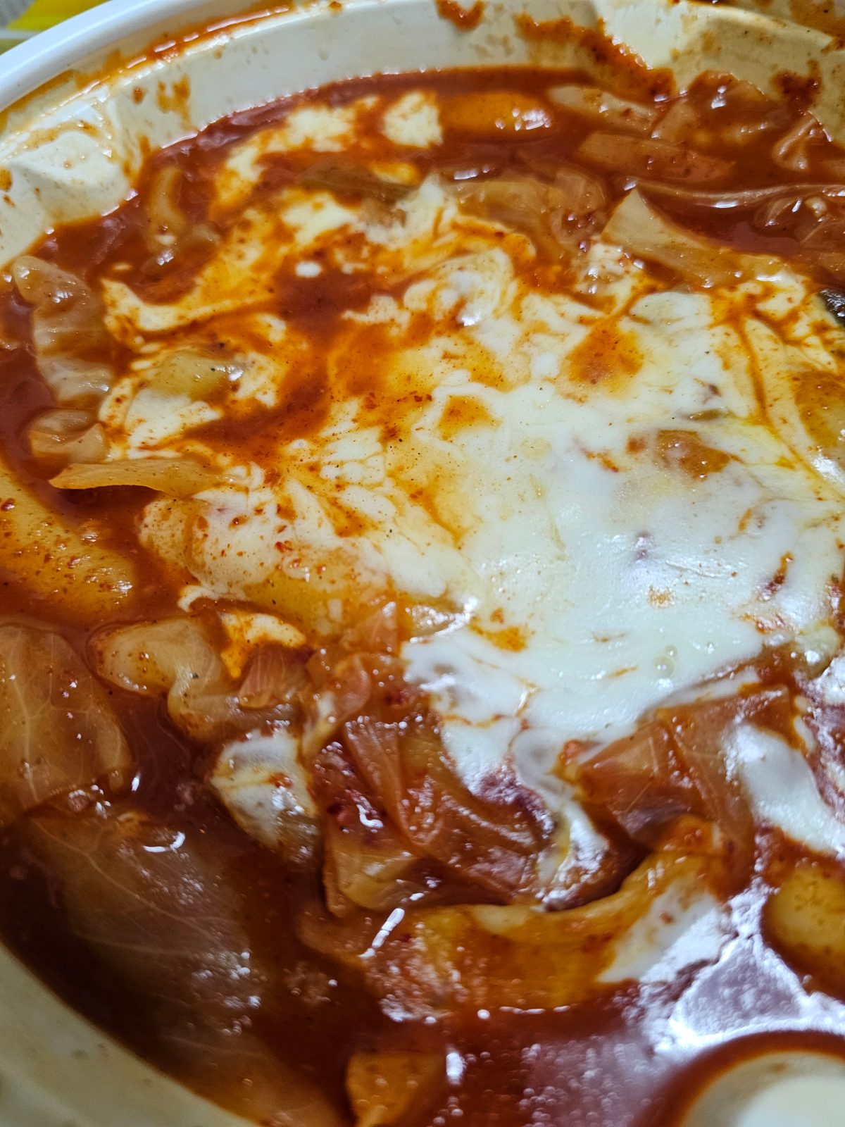 Spicy tteokbokki with cheese beside the chicken
