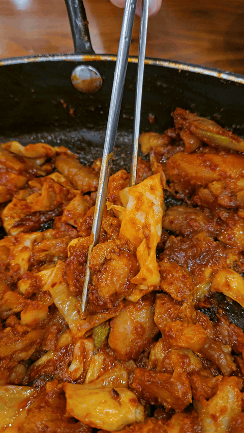 Piece of spicy dakgalbi lifted from the pan at Yugane Dakgalbi Daegu