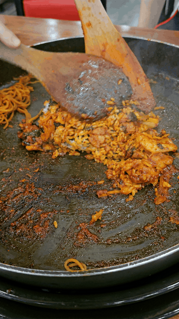 Fried rice mixed into remaining dakgalbi sauce on a hot pan in Daegu