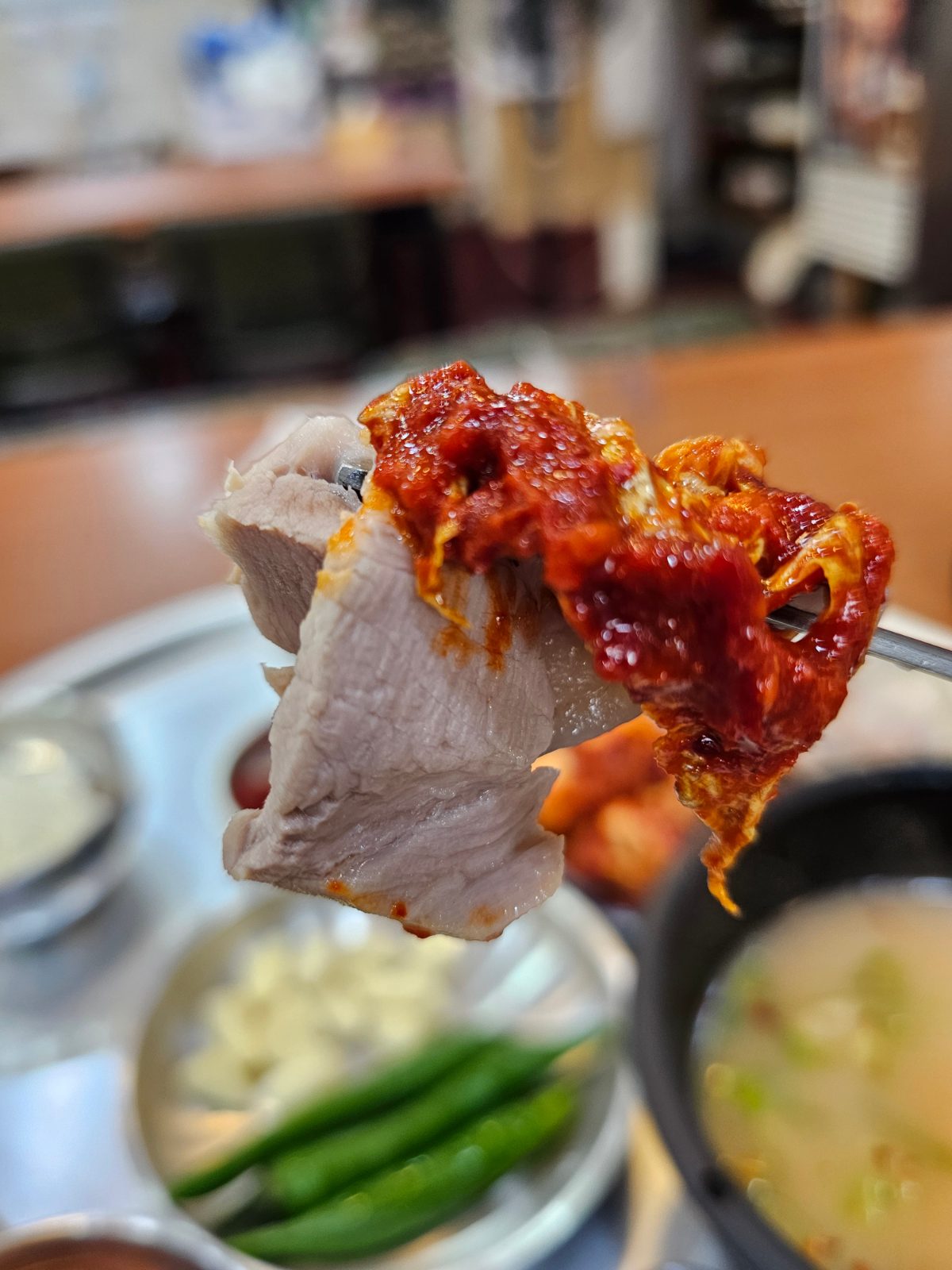 Slice of bossam pork topped with red bossam kimchi