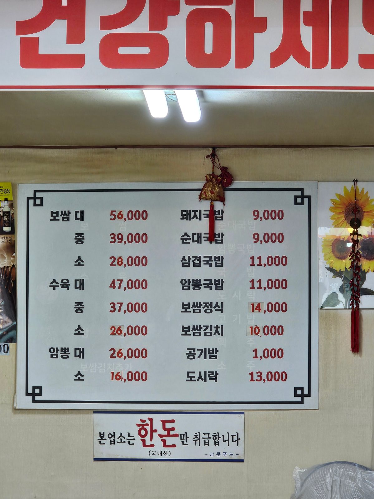 Wall menu at Jinju Wang Bossam showing bossam, suyuk, gukbap, and set meal options