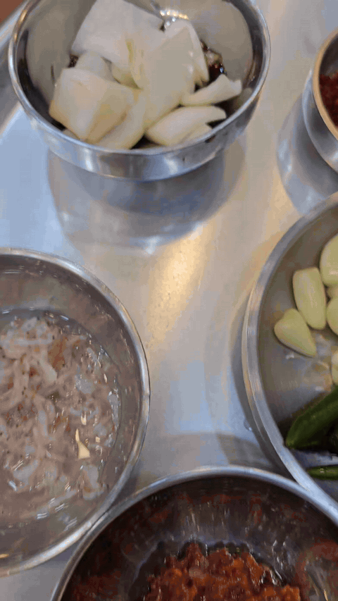 Table setting with onion, garlic, chili, vegetables, and side ingredients