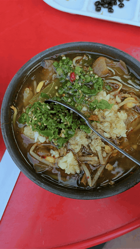 Beef soup covered in a mound of chopped chili and garlic