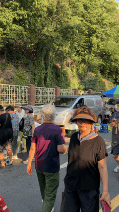 Crowds walking along the road through the Dalseong Park dawn market in Daegu