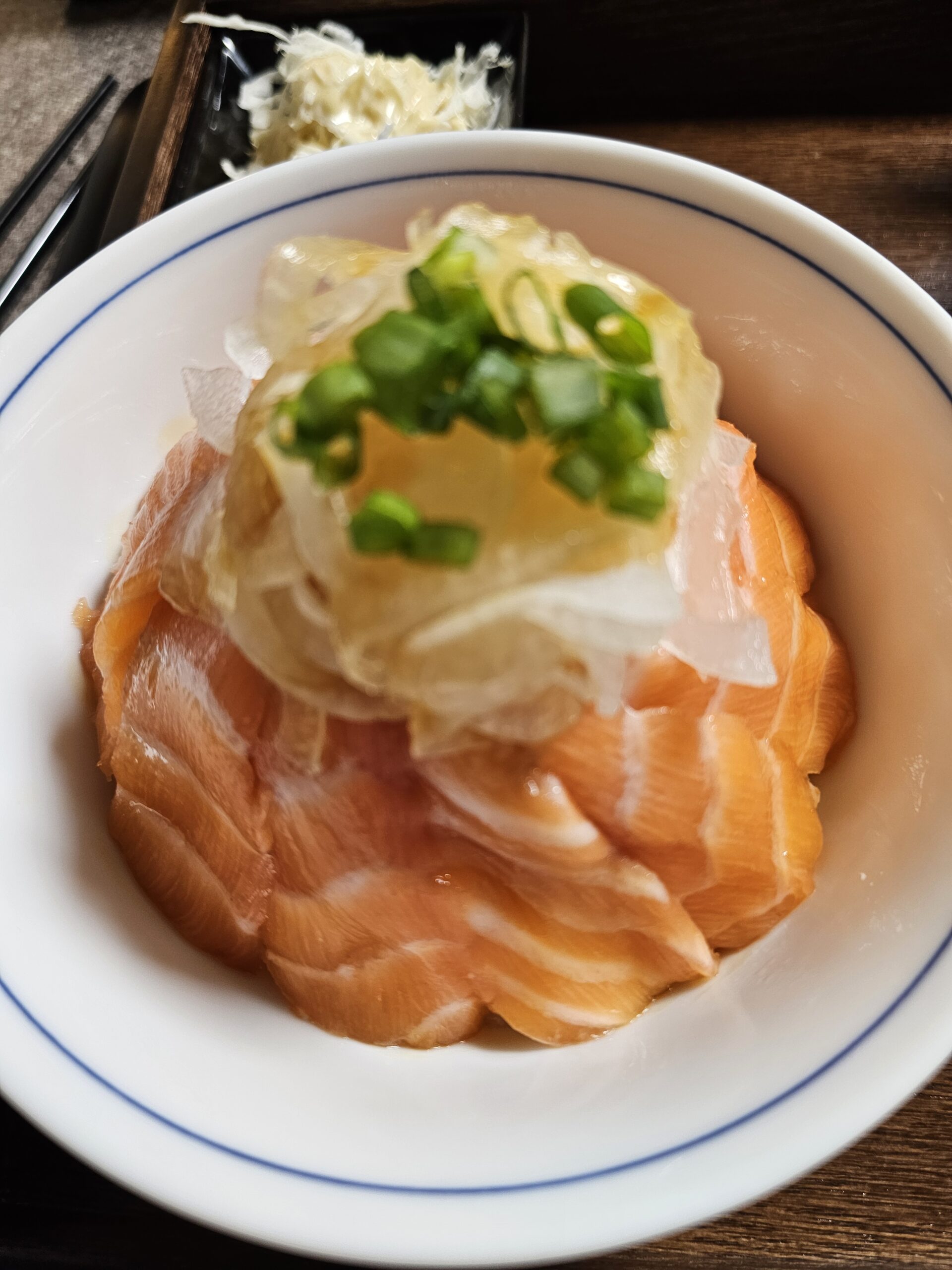重なったサーモン、玉ねぎ、ねぎがのったサーモン丼