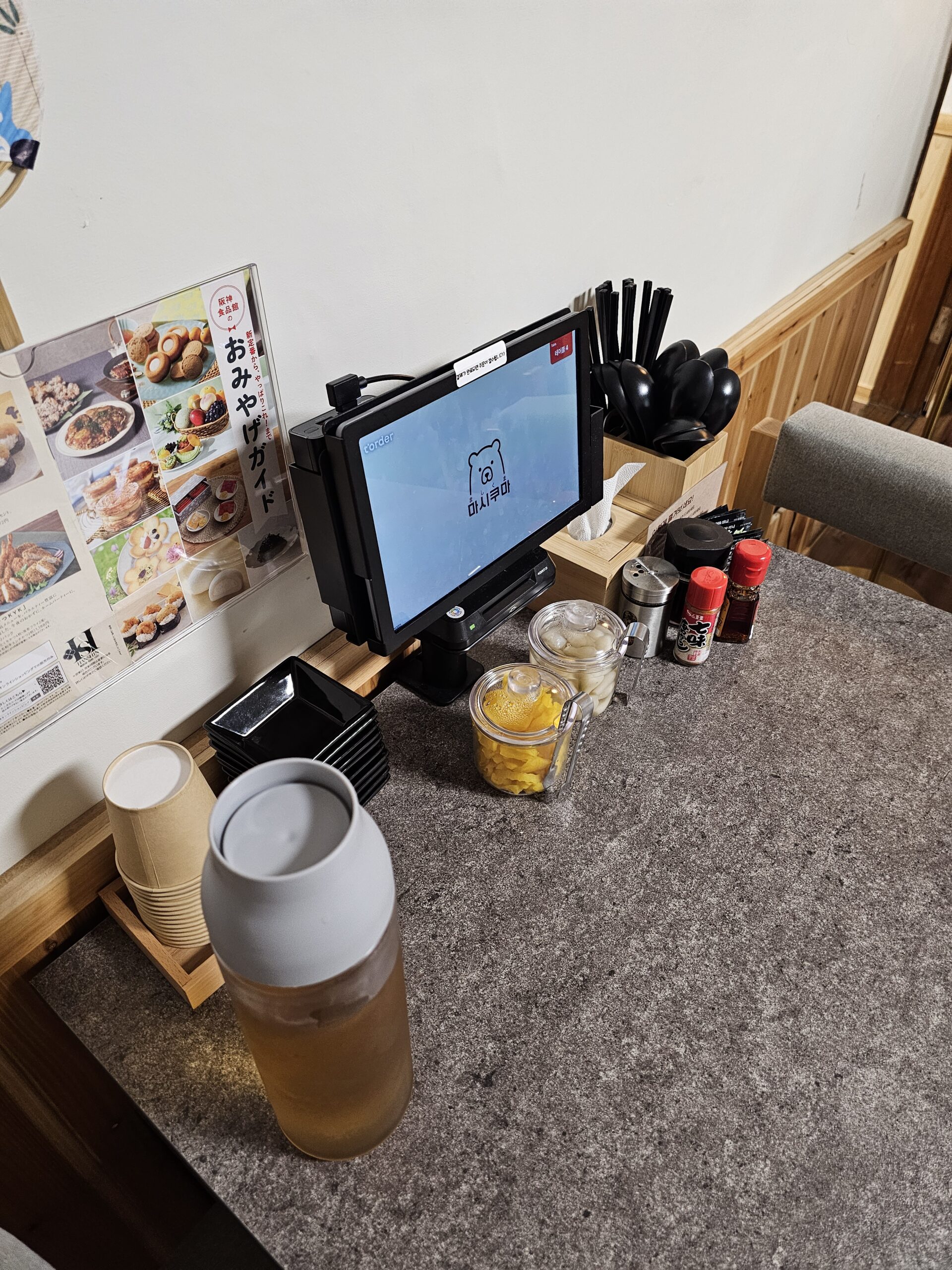 たくあん、水、カトラリーの横にあるクマのロゴ入りタブレット