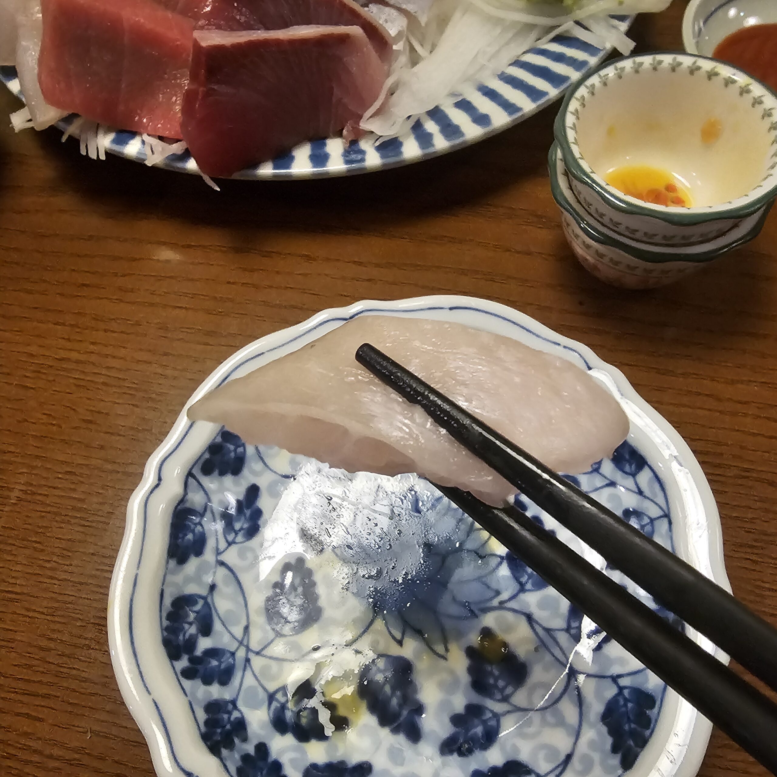 皿の上で箸で持ち上げた厚切りのエンガワ