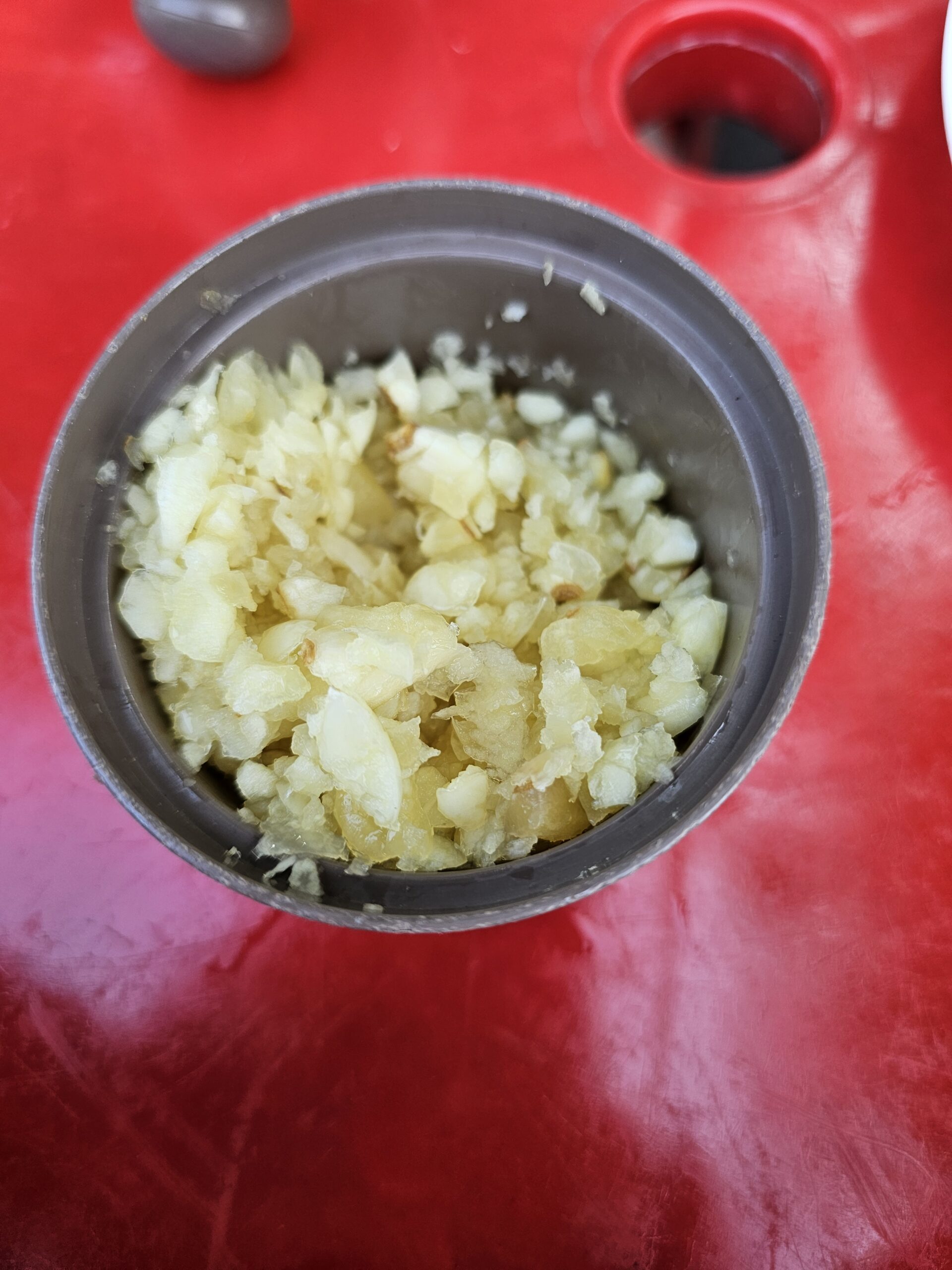 Container of coarsely chopped garlic on the table