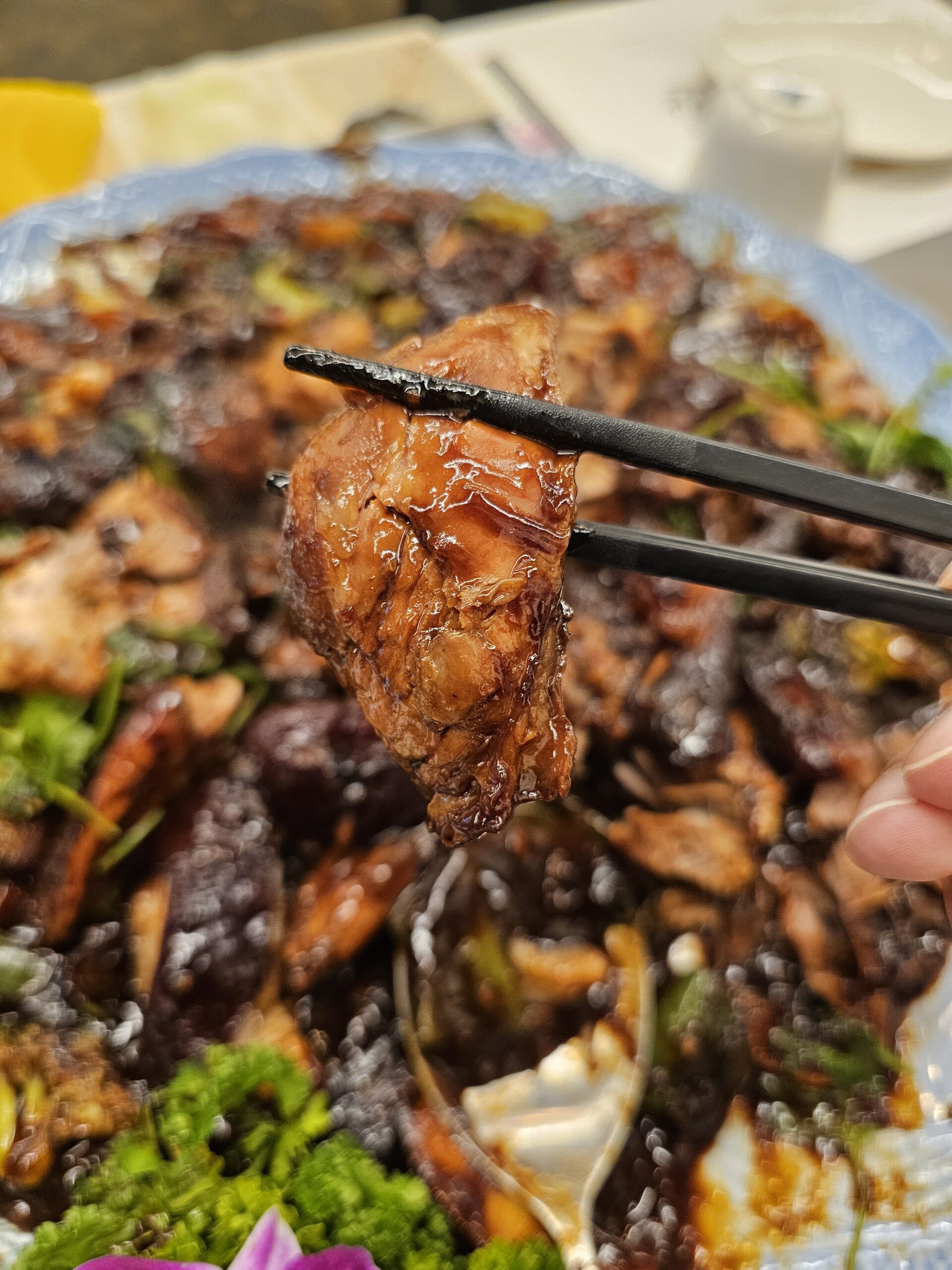 箸で持ち上げた、ソースの絡んだ豚肉の赤身