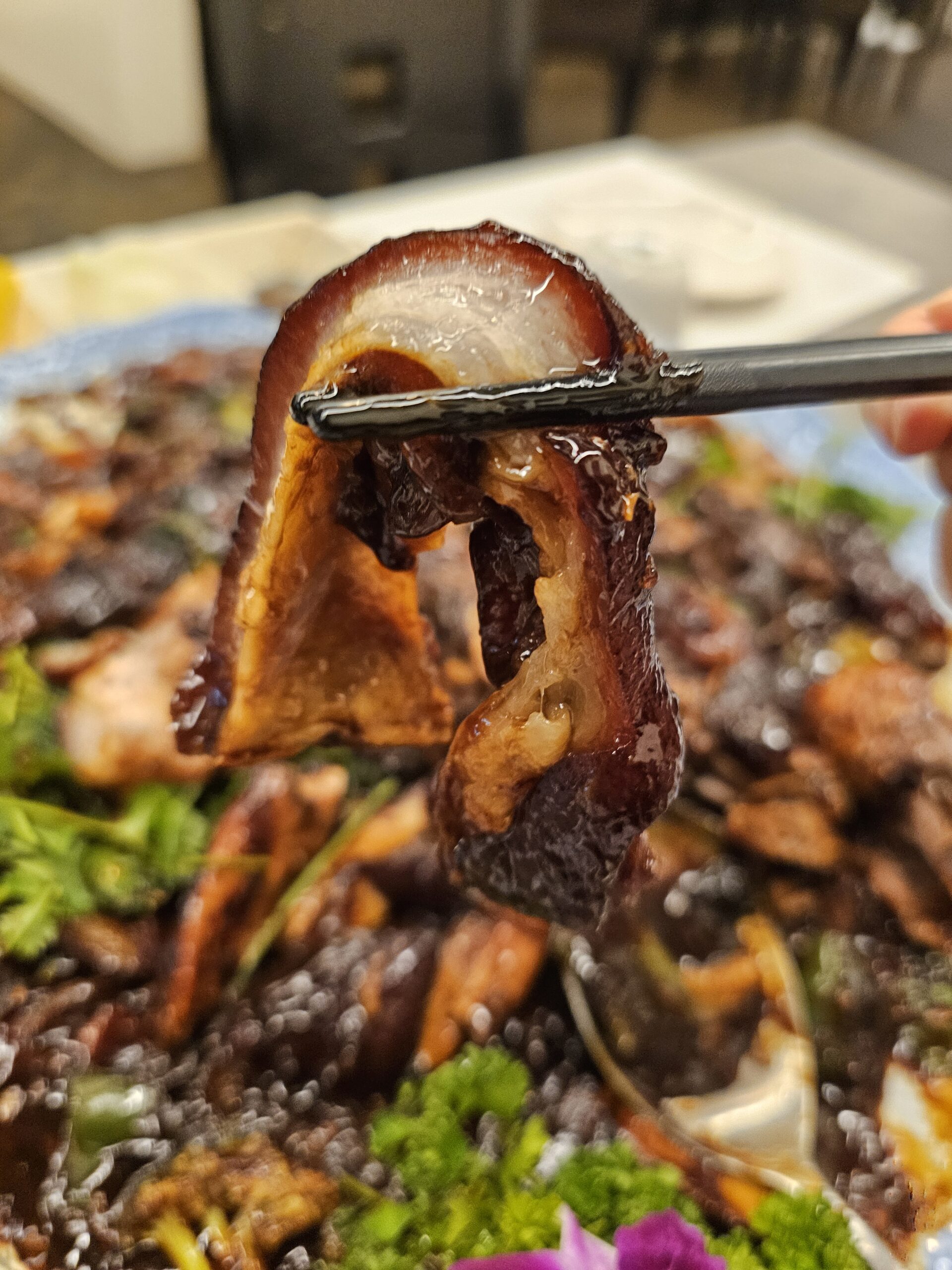 持ち上げた豚肉から見える、皮の下の厚い脂身の層