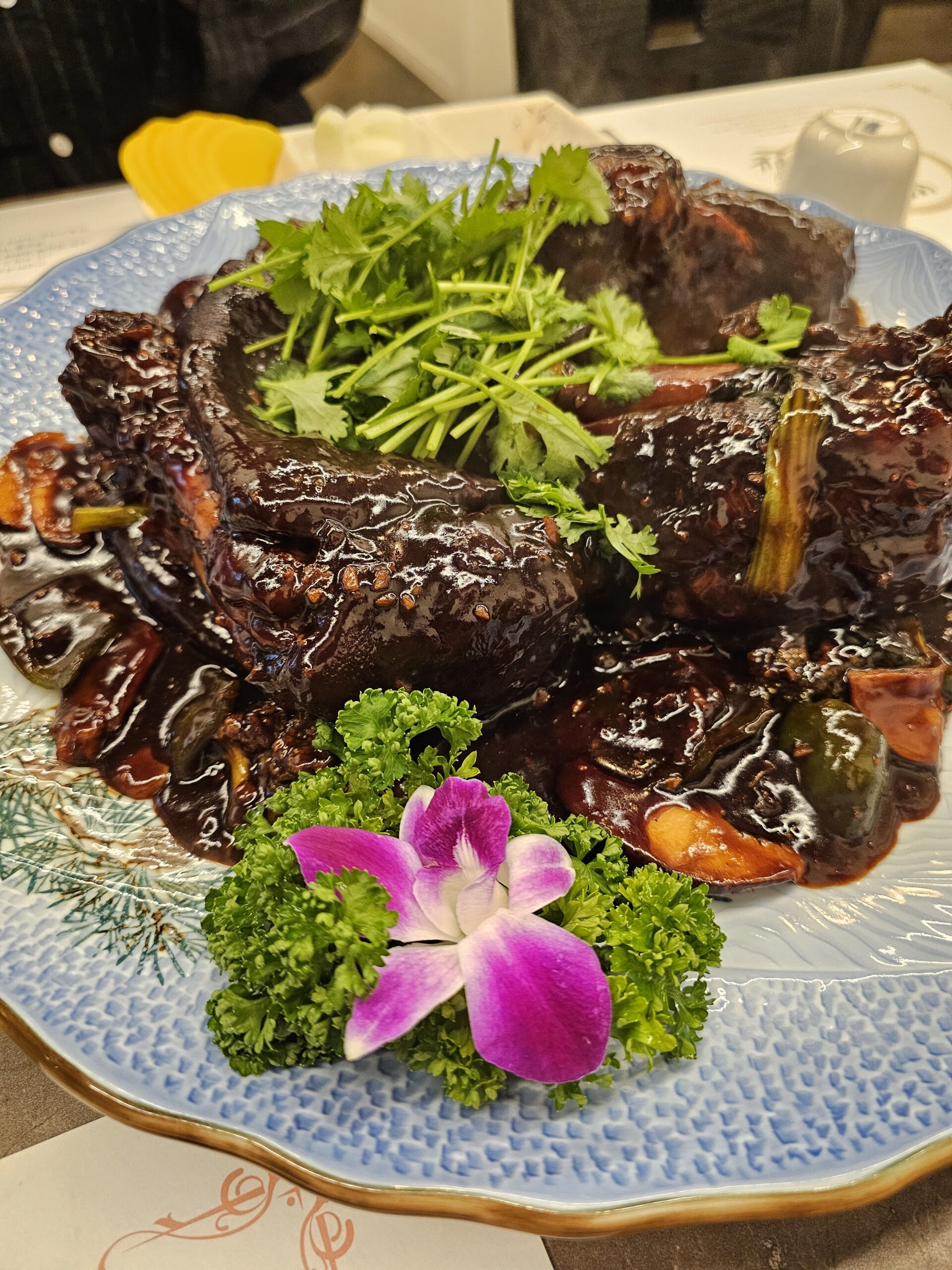 つやのある濃い色のソースがかかり、パクチーがのったホンショー豚足料理(홍쇼족발요리)
