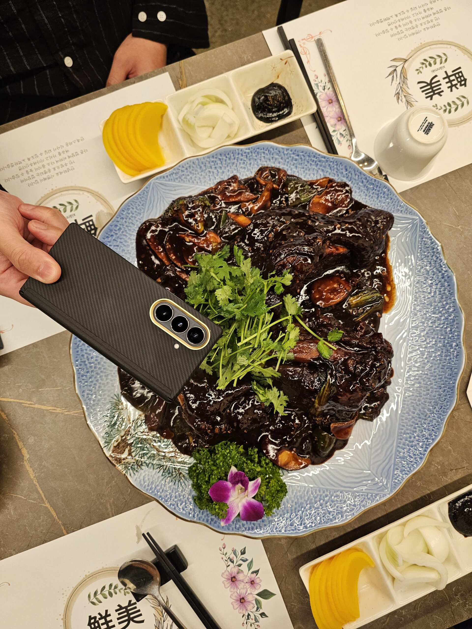 スマートフォンと並べたホンショー豚足料理の大皿