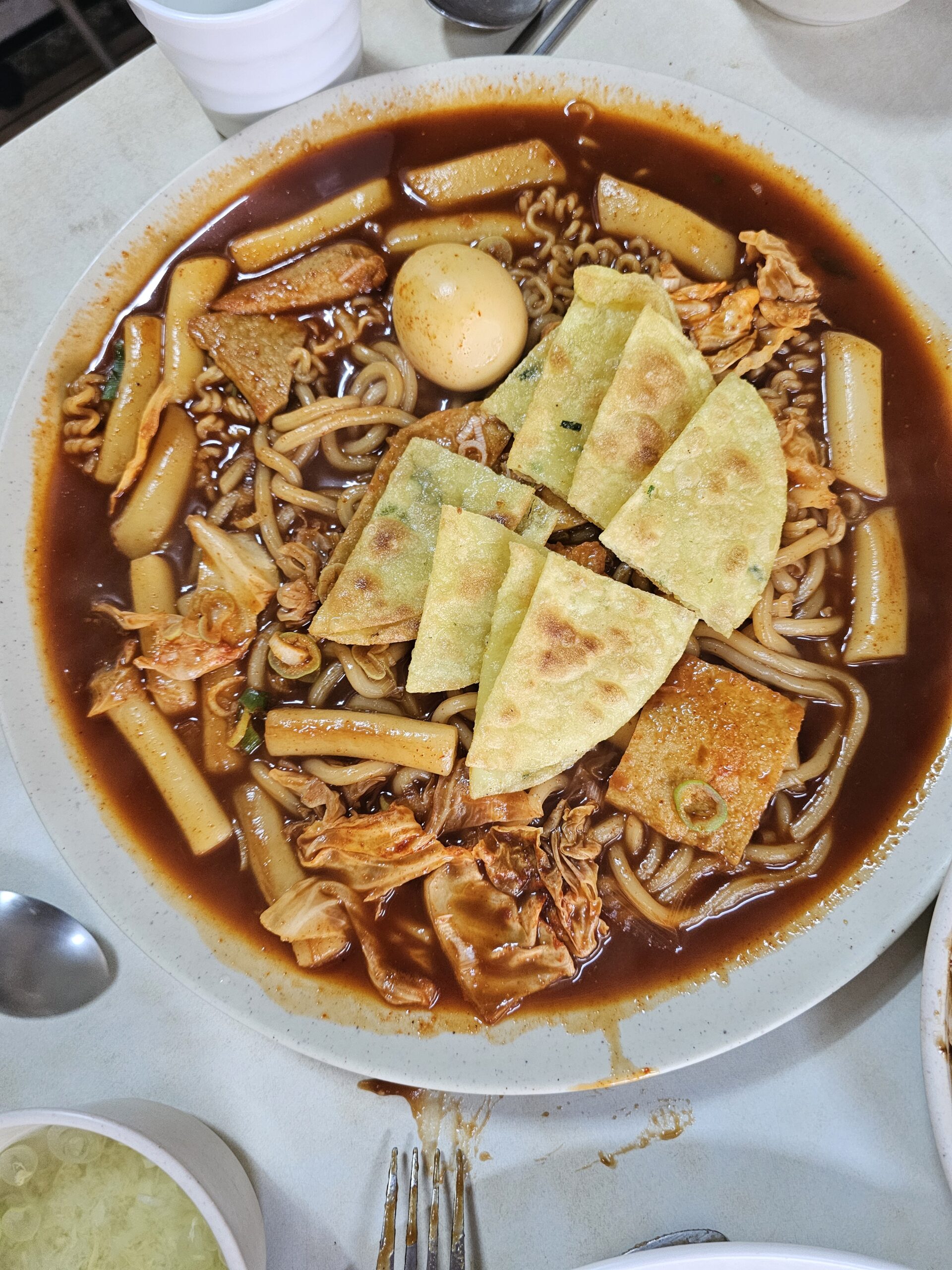 Wide plate of rice cakes with sauce reaching the edges