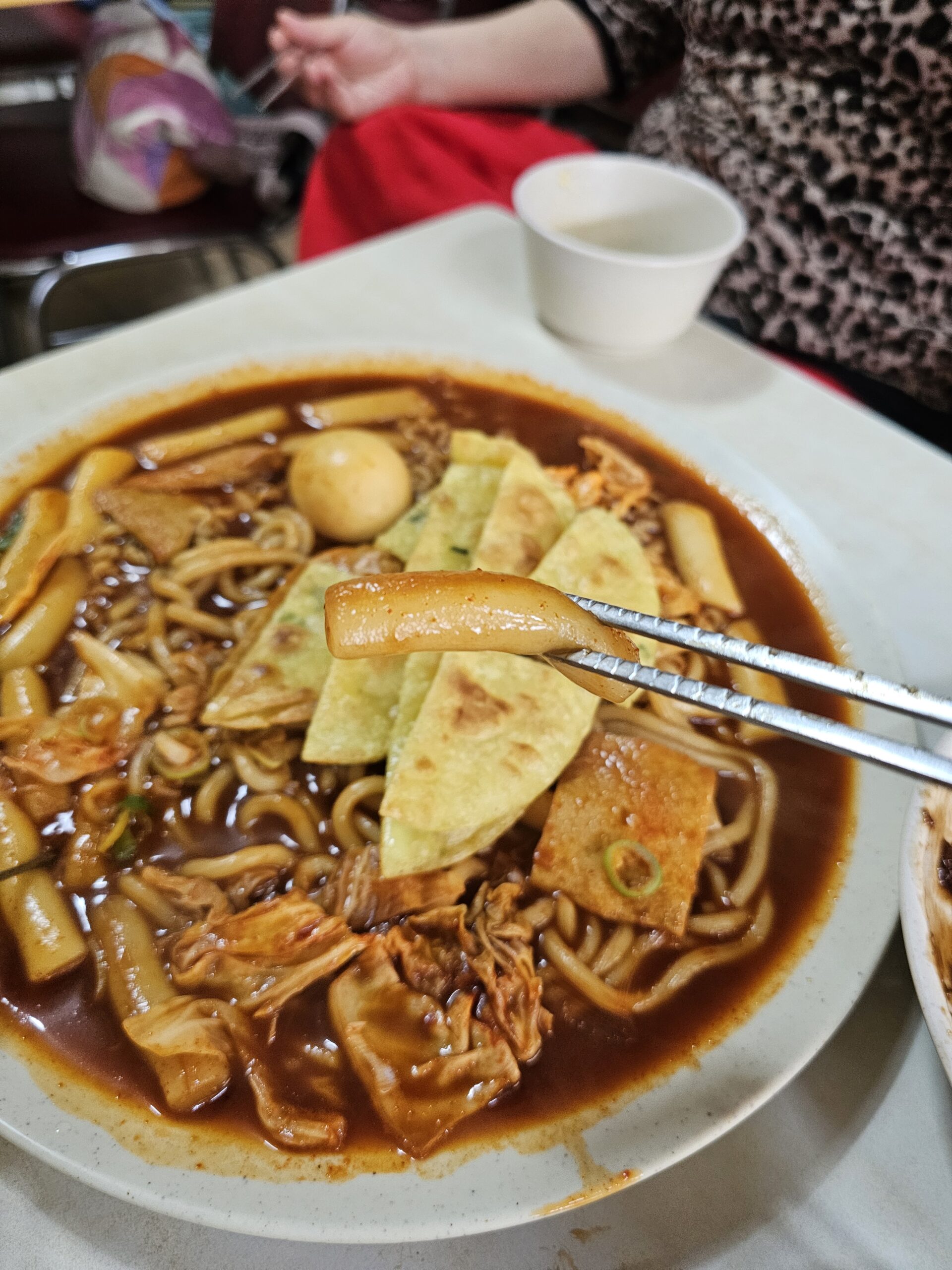 Sauce-coated wheat rice cake held with chopsticks