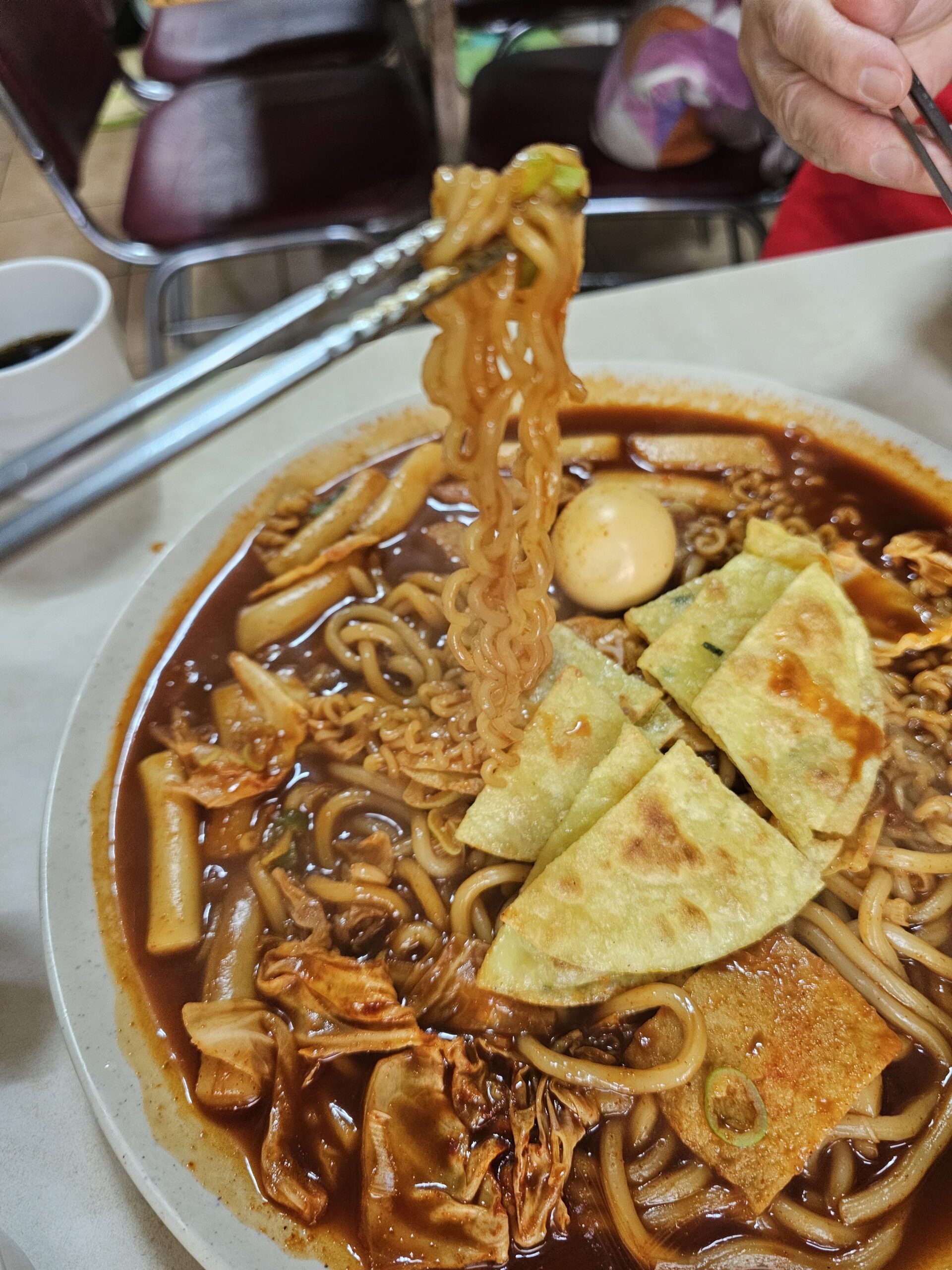 Curly noodles lifted with sauce clinging between the strands