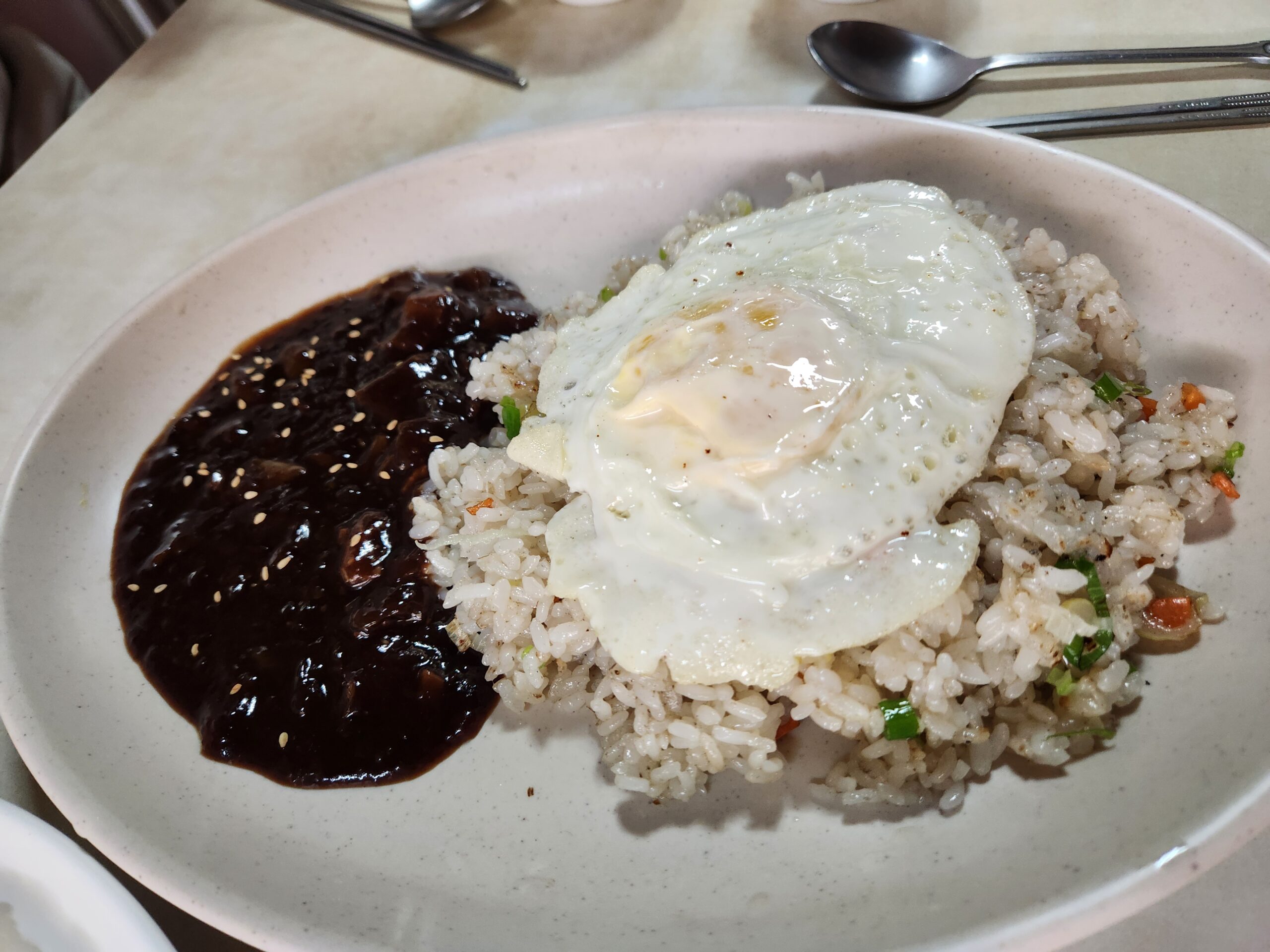 Bokkeumbap with scallion, carrot, and sesame-topped black bean sauce
